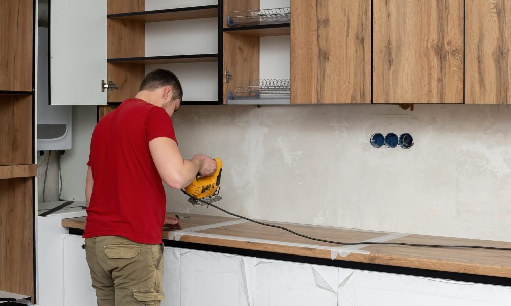 man-is-using-yellow-drill-install-shelf-kitchen